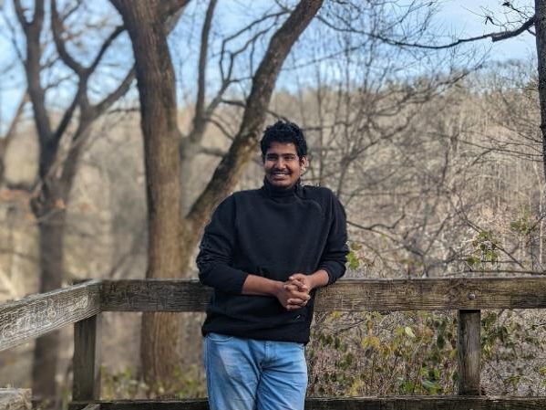 Ashwin standing at a wooden overlook among bare winter trees